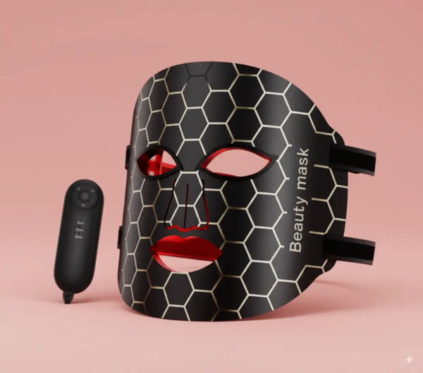 Black honeycomb patterned beauty mask with red accents on a pink background